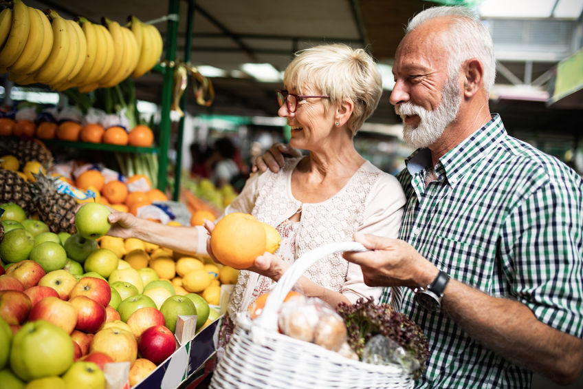 Senior family couple choosing bio food fruit and vegetable on the market during weekly shopping